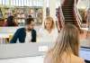 Na co zwrócić uwagę wybierając kierunek studiów prawniczych za granicą Międzynarodowa grupa studentów pracuje przy laptopach w bibliotece kampusu.